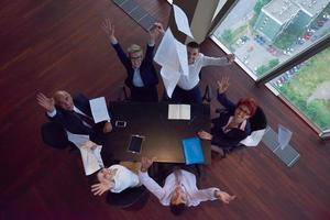 top view of business people group throwing dociments in air photo