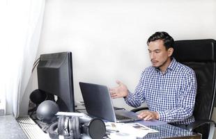 Man with worried and confused look holding hear while looking at the laptop photo