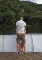 A couple holding each other tightly on a river boat photo