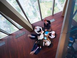 top view of business people group throwing dociments in air photo