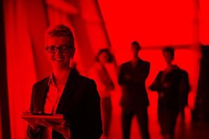 business woman  at office with tablet  in front  as team leader photo