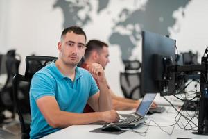 Group of Casual business man working on desktop computer in modern open plan startup office interior. Selective focus photo