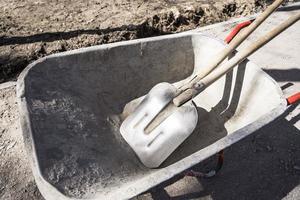 old reliable working wheelbarrow with shovels on a construction site photo