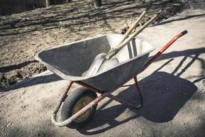 old reliable working wheelbarrow with shovels on a construction site photo