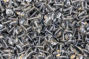 A lot of metal self-tapping screws. background of self-tapping screws. photo