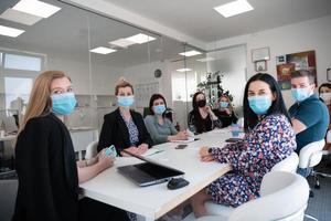real business people on meeting wearing protective mask photo