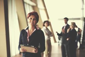 business woman  at office with tablet  in front  as team leader photo