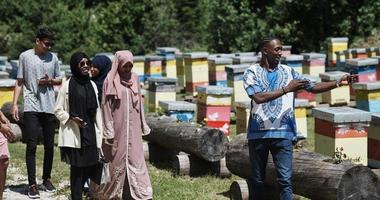 grupo de personas que visitan la granja local de producción de miel foto