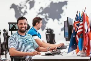 Group of Casual business man working on desktop computer in modern open plan startup office interior. Selective focus photo