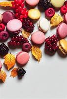 composición de macarrones. marco hecho de bayas de otoño y macarons. otoño, concepto de otoño. endecha plana, vista superior, espacio de copia foto