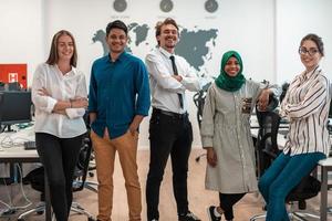 Portrait of young excited multiethnics business team of software developers standing and looking at camera at modern startup office photo