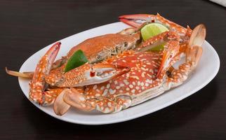 Boiled crabs on the plate and wooden background photo