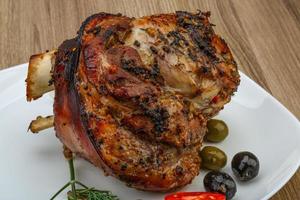 Pork knee on the plate and wooden background photo