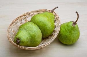 Green pears in a basket on white background photo