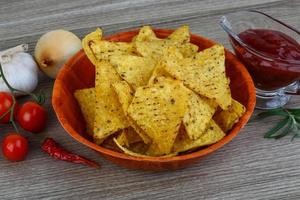 nachos en un bol sobre fondo de madera foto