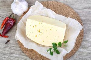 Cheese on wooden board and wooden background photo