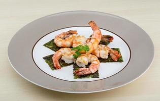 Tiger shrimps on the plate and wooden background photo