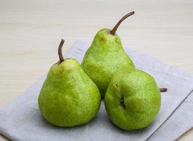 Green pears on wooden background photo