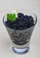 Black caviar in a bowl on wooden background photo