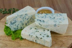 Blue cheese on wooden board and wooden background photo