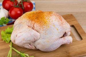 Raw chicken on wooden board and white background photo