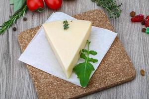 Parmesan cheese on wooden board and wooden background photo