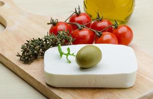 Feta cheese on wooden board and wooden background photo