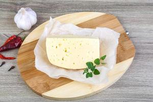 Cheese on wooden board and wooden background photo