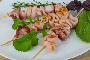 Grilled squid on the plate and wooden background photo