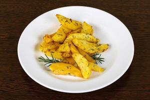 Roasted potato on the plate and wooden background photo