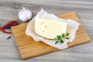 Cheese on wooden board and wooden background photo