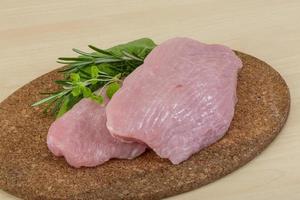 Turkey steak on wooden board and wooden background photo