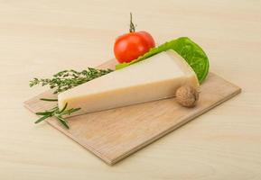 Parmesan cheese on wooden board and wooden background photo