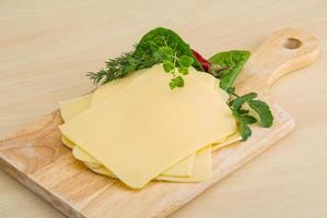 Sliced sheese on wooden board and wooden background photo