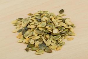 Pumpkin seeds on wooden background photo