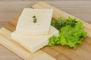 Yellow cheddar on wooden board and wooden background photo