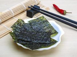 Nori sheets in a bowl on wooden background photo