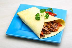 Burrito on the plate and wooden background photo