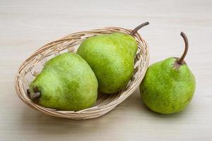 Green pears in a basket on white background photo