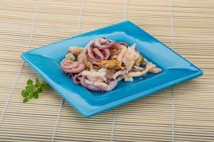 Seafood cocktail on the plate and wooden background photo