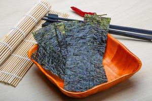 Nori sheets in a bowl on wooden background photo