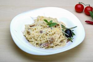 Pasta Carbonara on the plate and wooden background photo
