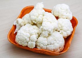 Cauliflower in a bowl on wooden background photo