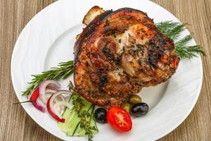 Pork knee on the plate and wooden background photo