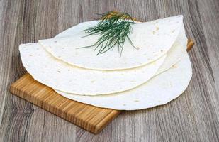 tortillas en tablero de madera y fondo de madera foto