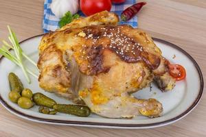 Grilled chicken on the plate and wooden background photo