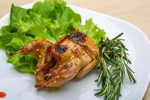 Roasted Quail on the plate and wooden background photo