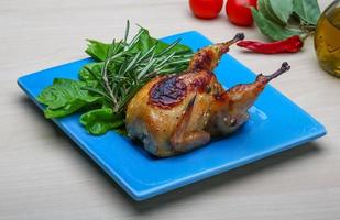 Roasted Quail on the plate and wooden background photo