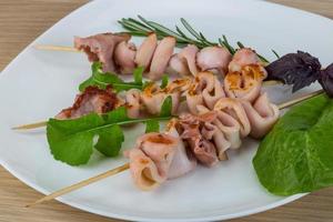 Grilled squid on the plate and wooden background photo