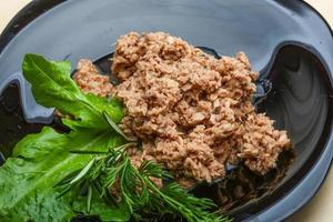 Cannded runa on the plate and wooden background photo